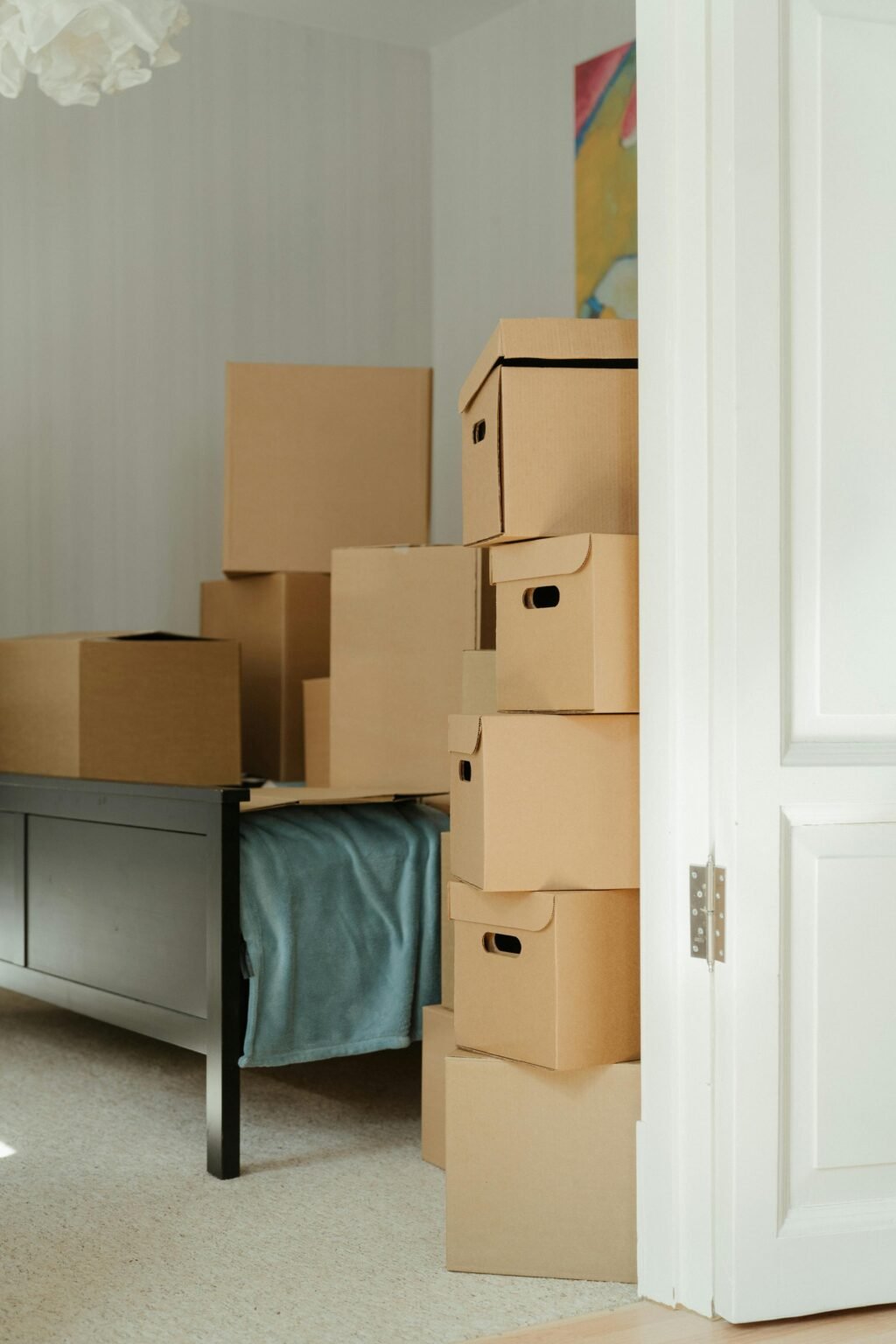 Cardboard boxes stacked in a bedroom, symbolizing a move or relocation.